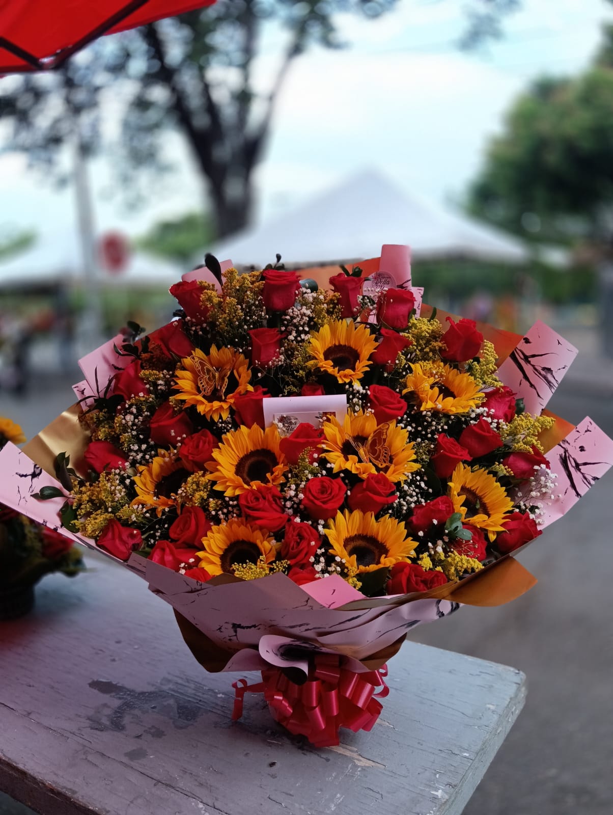 Bouquet mixto de girasoles y rosas rojas con mariposas