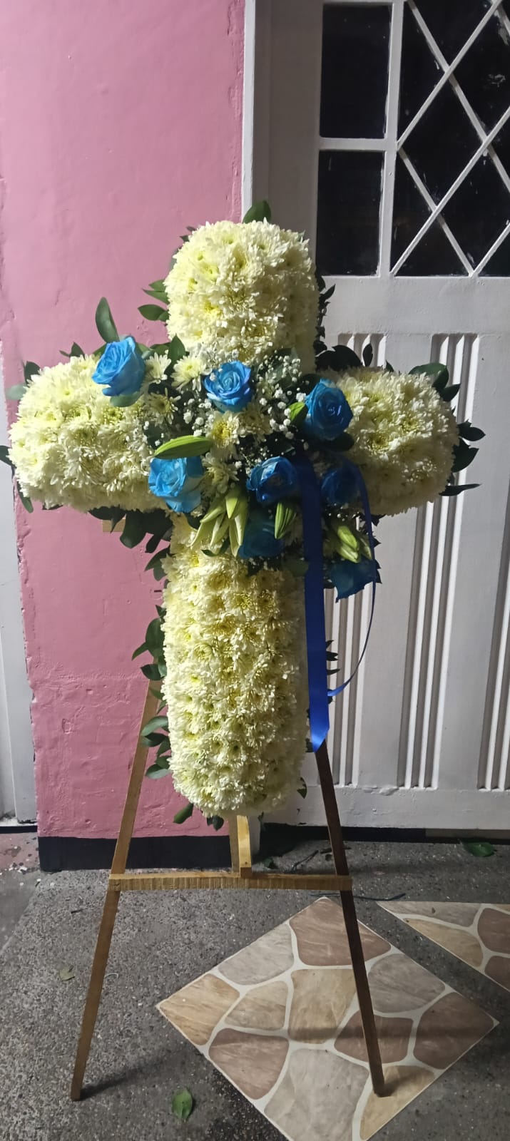 Cruz floral de condolencias con rosas azules y crisantemos