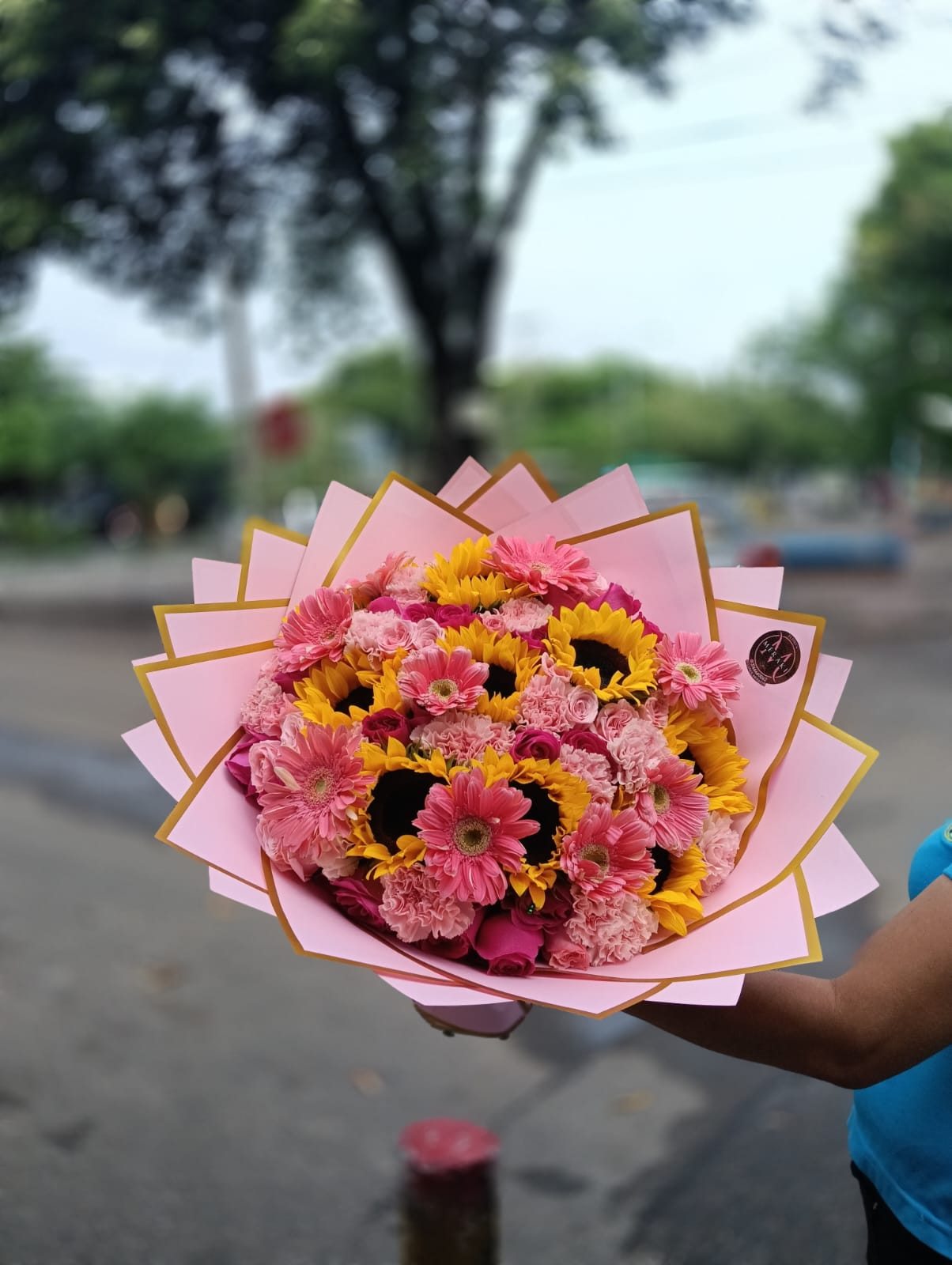 Ramo primaveral de girasoles y gerberas en envoltura rosa
